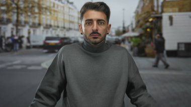 Şehir caddesinde bağırmak için elleri olan, trafiği bulanık, kaldırımı açık bir adam..