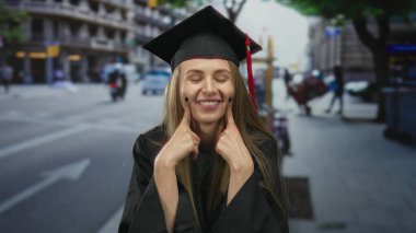Yoğun bir şehir caddesinde kep ve cübbe içinde gülümseyen mezun bir kadın, arka planda hareketli bir şehir hayatı ile neşe ve başarıyı somutlaştırıyor.