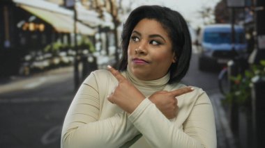 Şehir merkezinin ortasında gün ışığı altında kendine güvenen bir ifadeyle caddeyi gösteren bir kadın..