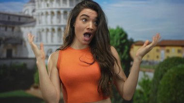 Genç İspanyol kadın güneşli bir öğleden sonra sidik kulesi binasının önünde omuz silkiyor..