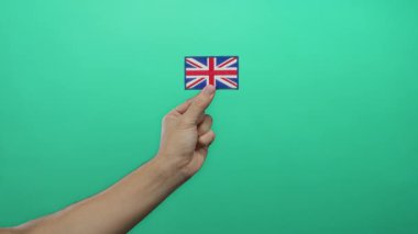 Beyaz adam yeşil arka plan duvarına karşı İngiltere bayrağı nakışı yapıyor..