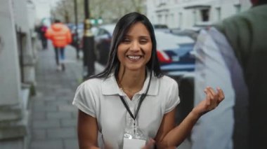 Genç bir kadın çalkantılı bir şehir caddesinde gitar çalıyor, şehir ortamında neşe ve enerji saçıyor..