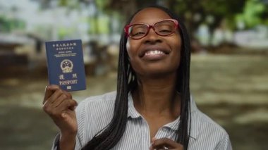 Şehir merkezinde elinde Hong Kong pasaportu olan kırmızı gözlüklü bir kadın gülümsüyor.