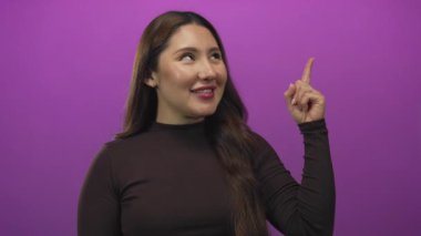 Kadın parmağını yukarı gösteren mor stüdyo gülümseme ve yukarı bakış ile; ilham.