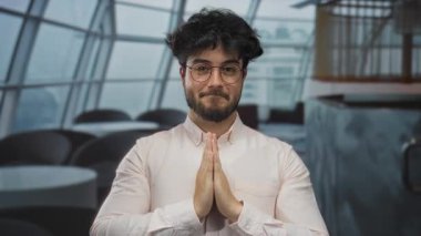 İspanyol adam modern bir restoran ortamında el ele meditasyon yapıyor, kafeterya ortamında huzur ve yansıma yayıyor..