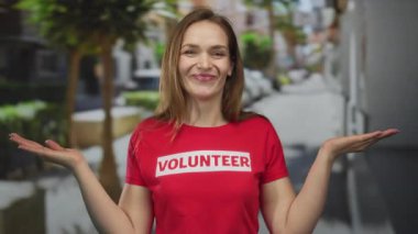 Parlak kırmızı gönüllü gömlekli kadın el ele tutuşuyor ve günışığında kameraya geniş bir şekilde gülümsüyor; iyimserlik.