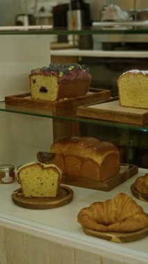 Somun keki ve kruvasan da dahil olmak üzere çeşitli hamur işleri, kapalı bir lokantadaki ahşap tepsilerde sergileniyor..