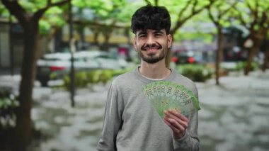 Kasaba ortamında elinde Rus rublesi olan bir adam gülümsüyor, şehir ve doğal karışımı yakalıyor..