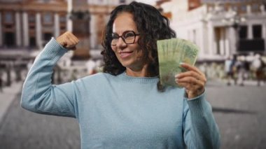 St. Peter Meydanı, Vatikan 'da elinde Arjantin banknotları tutan ve kolunu güçlü bir şekilde esneten orta yaşlı bir kadın..