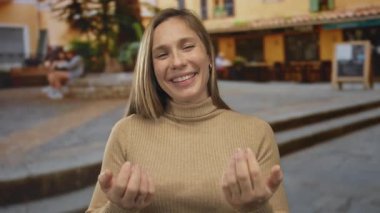 Sarışın genç kadın iki eliyle şehir sokağına işaret ediyor; davete hoş geldiniz..