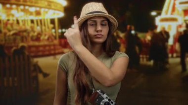 Şapkalı İspanyol bir kadın, neşeli bir caddede, bulanık ışıklar ve atlı karınca ile çevrili, açık hava şenliği ve gençlik keşiflerini yakalıyor..