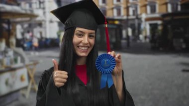 Mezuniyet şapkası takan, elinde mavi kurdele olan bir kadın.