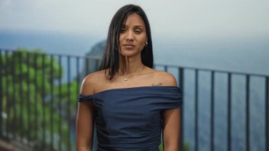 Okyanus manzaralı sakin bir plajda zafer jesti yapan İspanyol bir kadın..