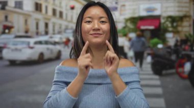 Yoğun şehir sokağında rahat bir şekilde gülümseyen bir kadın, etrafında arabalarla, günlük kıyafetleriyle, şehir hayatının özünü yakalıyor..