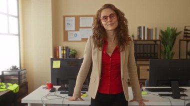 Güvenle gülümseyen bir kadın ofisteki bilgisayar, modern iç mimari profesyonel atmosfer..