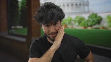 Sakallı genç adam güneşli bir günde sidik kulesinin yanında gizli bir jest yapar. İtalya 'da seyahat deneyiminin canlı ruhunu yakalar..