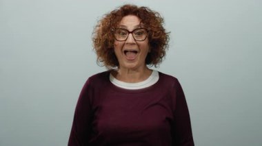 Dışlanmış beyaz bir arka plana karşı duran anlamlı bir yüzle bir sırrı fısıldayan bir kadın..