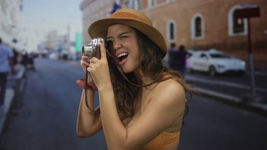 Elinde kamera olan İspanyol bir kadın, sokak manzaralarını inceliyor, genç bir turist olarak yaptığı seyahatler sırasında kentsel anları yakalıyor..