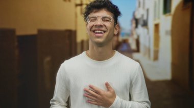 Tarihi caddede eli göğsünde yuvarlak gözlüklü ve beyaz gömlekli İspanyol genç adam, eğlence..