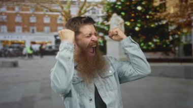 Gündüz vakti kalabalık şehir caddesinde elleri havada, ağzı açık bağıran beyaz sakallı genç bir adam..