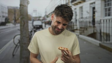 Kentsel caddede taze waffle tutan adam gevrek dokusunu ve şurubunu incelerken; açlık arzulu lezzet.