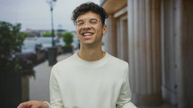 Gündüz vakti kalabalık bir şehir caddesinde konuşan genç bir İspanyol el hareketi ve anlamlı yüz ile iletişim ifadesi belirsizliği.