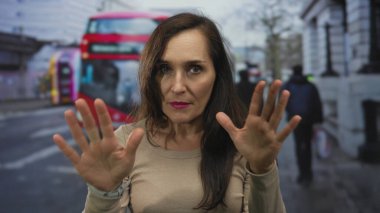 İki elini de ileri uzatan genç İspanyol kadın şehir sokaklarında sakin bir jest, dinginlik farkındalığı.