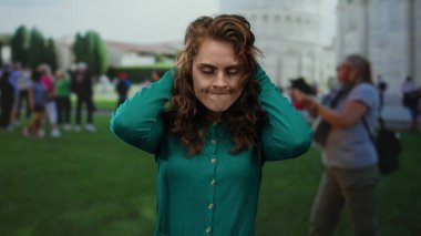 Canlı bir şehir ortamında turistler arasında sidik kulesinin önündeki hayal kırıklığını ifade eden bir kadın, duygu ve ikonik seyahat deneyiminin bir karışımını yakalıyor..