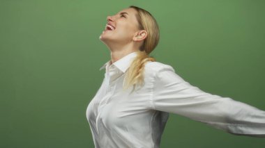 Beyaz bir gömlekle gülümseyen bir kadın kollarını uzatmış canlı yeşil bir arka plana karşı mutluluk ve güveni somutlaştıran..