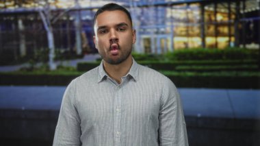 Kısa sakallı, çizgili gömlek çantalı adam. Meşgul şehir caddesinde dudaklar. Akşam ışıkları altında..