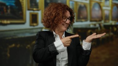 Bir sanat galerisinde kendine güveni olan, zarif bir stili ve coşkuyu sergileyen, yaratıcı bir iç mekanda kendine güvenen bir kadın..