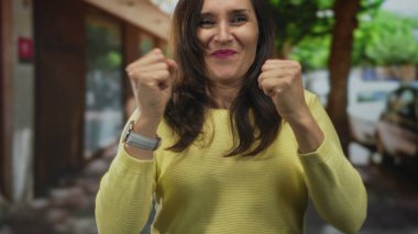 Sokakta gülümseyen kadın yumrukları sımsıkı sarıydı güneşli bir günde heyecan ve neşe ifade ediyordu..