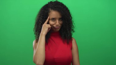 Stüdyoda kırmızı kolsuz bluz giyen, yaratıcı düşünen genç İspanyol kadın..