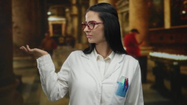 Beyaz üniformalı bir kadın, kırmızı gözlüklü, tarihi bir kilise arka planında, bilim ve mirası ön plana çıkarıyor..