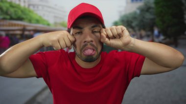 İspanyol kurye, hediyelik eşya tezgahlarıyla kırmızı şapkalı ve tişörtlü yanaklarını dışarı çıkarıyor..