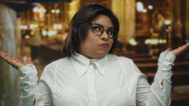 Kilisede el ele tutuşan, düşünceli düşüncelere dalan, gözlük takan, samimi bir anda yakalanan, kültür ve kimliğe önem veren bir kadın..