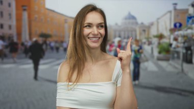 Aziz Peter Meydanı 'ndaki bir binaya gülümseyen ve parmağını yukarı gösteren bir kadın. Huzur..