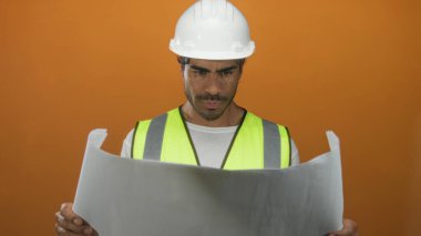 Stüdyoda sağlam şapka ve yansıtıcı yelek giyen insan mühendisi, yenilikçi konsantrasyon hırsı.