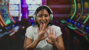 Arka planda kumar makineleri olan bir kumarhanede müzikten hoşlanan genç bir kadın rahat ve çekici bir atmosferi ön plana çıkarıyor..