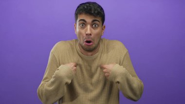 Kendine güveni tam bir erkek jest sanatıyla karışık parlak bir stüdyoda mor renkte yıkanmış İspanyol enerjisinin bulunduğu canlı bir arkaplan önünde kendini gösteriyor..