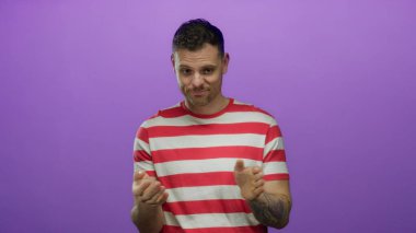Kırmızı çizgili tişörtlü İspanyol genç adam izole edilmiş mor bir arka plana karşı duruyor düşünceli bir ifade ve anlamlı el hareketleriyle.