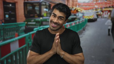 Siyah gömlekli genç adam şehir caddesinde açık el hareketi sergiliyor; belirsizlik sorusu kafa karışıklığı.