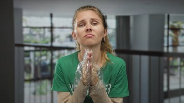 Kadın içeride eldiven içinde dua ediyor, gönüllü sarışın genç ve hayal kırıklığına uğramış..