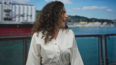 Tekne güvertesinde elini kaldırmış gülümseyen beyaz gömlekli İspanyol kadın. Tatil mutluluğu..