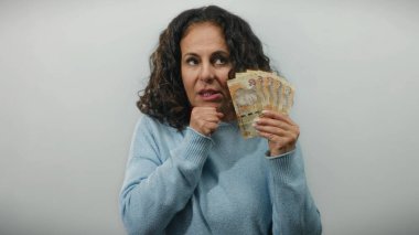 Güney Afrika Rand 'i elinde tutan orta yaşlı bir kadın soyutlanmış beyaz bir geçmişe karşı düşünceli bir ifadeyle.