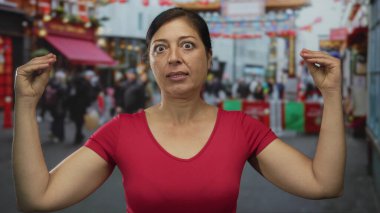 İspanyol kadın, kalabalık şehir caddesinde parmaklarını çimdikleyerek dik dik dik bakarken, şaşkınlık ve hayal kırıklığı içinde..