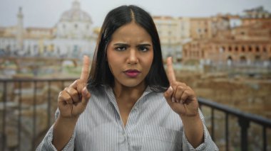 Bir kadın, Latin kökenli genç Latin asıllı Latin asıllı bir Latin 'in sokak harabelerinde sıkı bir jest yaparak ellerini kaldırdı..