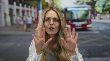 Ağzı açık bir kadın sokakta sesleniyor, genç sarışın şehir sakini gözlüklü banliyö çalışanı otobüsü selamlıyor..