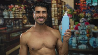 Adamın biri gülümsüyor ve elinde losyon şişesi var. İçi antika dekorlarla dolu. Cilt bakımı özgüven eksikliği..