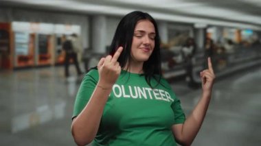 Yeşil gönüllü gömlekli kadın havaalanı terminalinde kaba davranışlar sergiliyor..